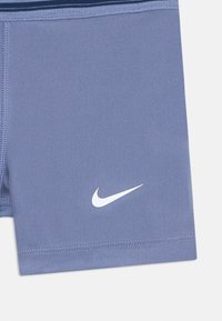 Nike šortky z jemnej modrej látky, so bielym logom na dolnej ľavej časti, s hladkou textúrou a minimalistickým dizajnom.