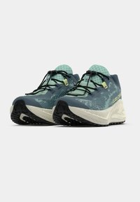 Ελαφριά παπούτσια για τρέξιμο σε σκούρο μπλε και μέντα πράσινο. Ανώτερο μέρος από δίχτυ, με υφασμένο σχέδιο, μαύρη λαστιχένια σόλα με πολυκατευθυντικό πέλμα.