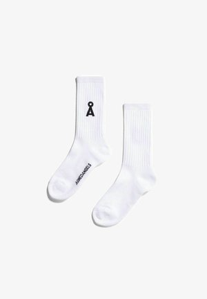 Weiße Baumwollsocken mit gerippter Textur, auf einer Seite mit einem schwarzen Logo und auf der Sohle mit dem Schriftzug "ARHEDANGELS" versehen. Maschinenwaschbar.