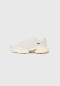 Lacoste sneakers in cream mesh upper with textured wave pattern, beige accents, and subtle logo on side. Thick white midsole and rubber outsole.