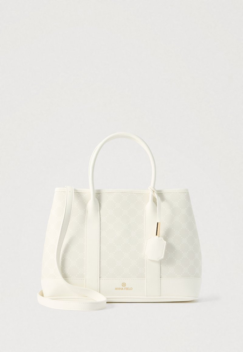 Geantă albă structurată cu două mânere, curea de umăr detașabilă, model subtil și logo auriu "Anna Field" la bază.