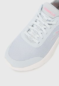 Baskets en maille bleu clair avec une tige à motifs, semelle en caoutchouc blanche et lacets plats. Présente un accent rose sur le côté.