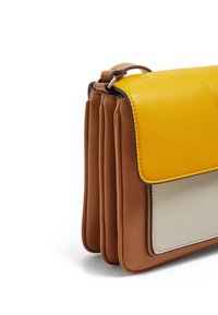 Borsa in pelle con lati a fisarmonica marroni, tasca anteriore grigia e chiusura a patta gialla con cinturino e fibbia su sfondo bianco.