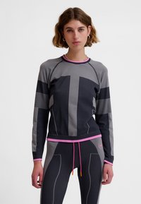 Sportowa bluzka z długim rękawem w kolorze szaro-czarnym z różowymi akcentami; cechuje ją dopasowany krój, poziome paski oraz teksturowane wzory.