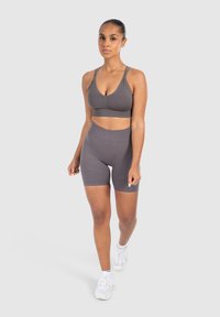 Grijze sportbh en set van hoog opgesneden shorts, gemaakt van gladde, rekbare stof. Heeft een eenvoudig ontwerp met dubbele schouderbanden.