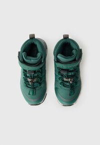Grüne High-Top-Schuhe mit einem Obermaterial aus strukturiertem Stoff, gesicherten Schnürsenkeln und einem gepolsterten Kragen, ausgestattet mit einer kontrastierenden Sohle und subtilen Logodetails.