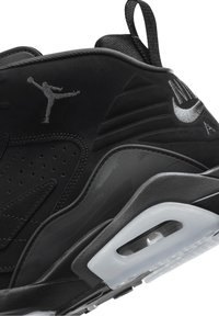 Černá sportovní obuv s texturovaným svrškem, perforovanými vzory a průhlednou podrážkou. Ozdobena stříbrným logem Jumpman a logem Nike.