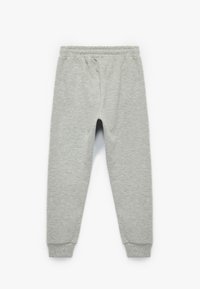 Grå joggebukser med elastisk talje, tætsiddende ben og ribbede manchetter. Fremstillet af blødt, tekstureret stof. Ingen synlige mønstre eller accenter.