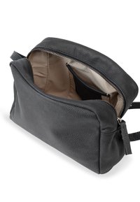 Borsa in pelle nera con superficie testurizzata, chiusura con zip e interno beige. Presenta una tasca interna e una tracolla regolabile.