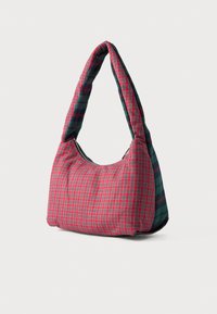 Sac à épaule matelassé avec un motif à carreaux rouge et vert, doté d'une texture douce et d'une forme arrondie, complété par une large bandoulière.