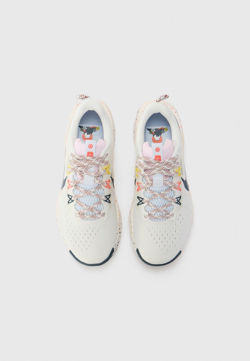 Białe buty sportowe z przewiewną siateczką na górze. Wielokolorowe sznurowadła i wkładki z graficznymi wzorami. Okrągły czubek i teksturowana podeszwa.