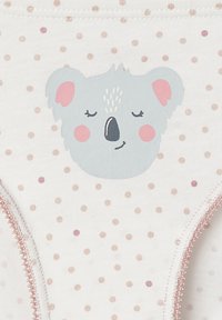 Baumwollunterwäsche mit einem weißen Hintergrund, die mit hellrosa Punkten versehen ist. Ein graues Koala-Gesicht ist zentriert und wird durch dezente rosa Akzente ergänzt.