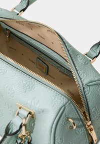 Borsa a tracolla verde menta con texture, dotata di finiture in oro, tasca interna con cerniera e fodera decorata con logo ripetuto.