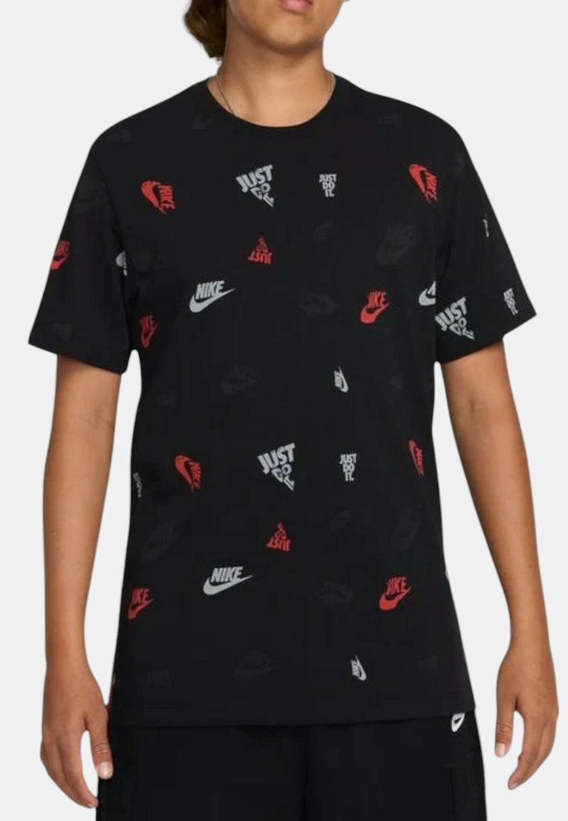 Maglietta nera con logo Nike ripetuto e testo "Just Do It" in rosso, bianco e grigio. Maniche corte, vestibilità casual, materiale in cotone.