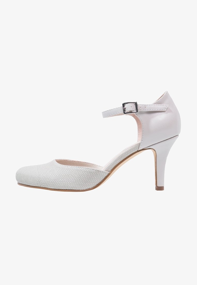 Chaussures à talons hauts blanches avec un bout texturé et une bride lisse autour de la cheville. Elles sont dotées d'une fermeture à boucle et d'un talon fin et effilé.