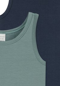 Two tank tops displayed together: one in light green cotton with smooth texture and rounded neckline, and one in dark navy cotton with similar design.