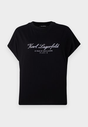 Juodas per didelis T-shirt, pagamintas iš medvilnės. Turi trumpas rankoves ir apvalų iškirpimą. Priekyje yra baltas užrašas: "Karl Lagerfeld 21 RUE ST-GUILLAUME PARIS."