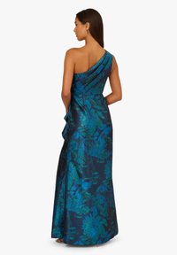 Večerní šaty na jedno rameno z tmavě modré látky s květinovými vzory v azurové a zelené barvě. Mají drapované akcenty a přiléhavý siluetu.