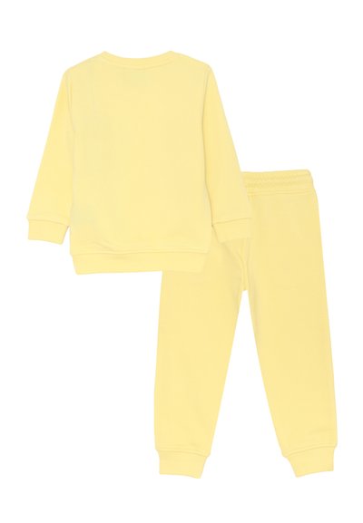Set di felpa a maniche lunghe giallo chiaro e pantaloni sportivi con vita elasticizzata abbinati, progettati per bambini, mostrati da dietro su uno sfondo bianco.