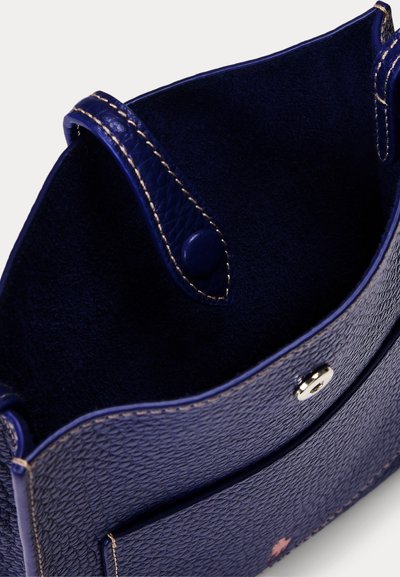 Borsa a mano in pelle testurizzata blu scuro aperta che mostra l'interno con chiusura a bottone automatico e dettagli di cuciture beige visibili.