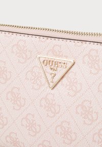 Portafoglio in tessuto rosa con texture intrecciata, motivo logo impresso e placca logo in tonalità oro. Chiusura a zip lungo il bordo superiore.