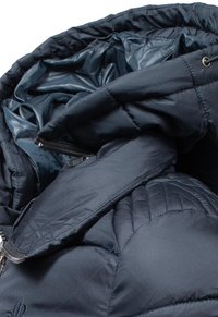 Mornarica puffer jakna s glatkom vanjštinom, kvadratnim šavovima, zatvaračem na zip i sjajnim unutarnjim oblogom.