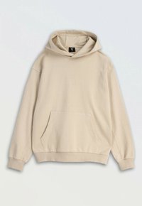 Beżowa, oversize bluza z kapturem, z kieszenią kangurzą, żebrowanymi mankietami i pasem, położona na jasnym tle.