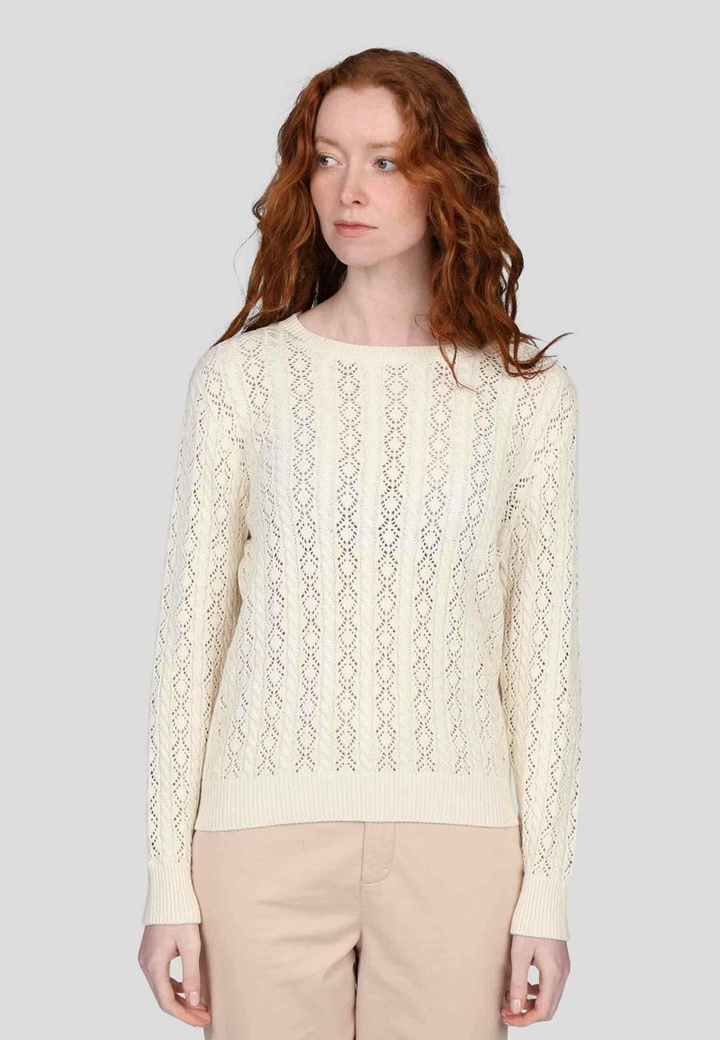 Pull en tricot couleur crème avec un motif en diamant, manches longues et poignets côtelés. Tissu léger et texturé avec une coupe décontractée.