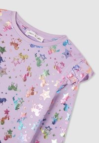 Fioletowa bawełniana bluzka z falbaniastymi rękawami, ozdobiona błyszczącym, wielokolorowym nadrukiem jednorożców i gwiazd w różnych metalicznych odcieniach.