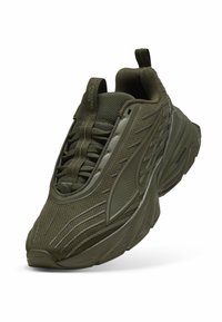 Sneaker atletica verde oliva con tomaia in rete testurizzata e suola in gomma liscia, caratterizzata da un design con lacci sicuro e collo imbottito.