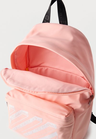 Ροζ σακίδιο με μαύρη λαβή, το κύριο διαμέρισμα ανοιχτό, μπροστινή τσέπη με φερμουάρ και λευκό γεωμετρικό σχέδιο, εμφανίζεται σε λευκό φόντο.