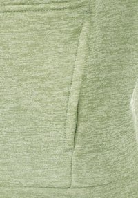 Felpa verde chiaro con tessuto a trama texturizzata e mélange, dotata di tasca frontale e dettagli cuciti sulle cuciture. Design morbido e casual.