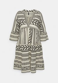 Svart och vit mönstrad klänning med V-ringning, trekvartslånga ärmar och volangkant. Tillverkad av lätt tyg med geometriska mönster.