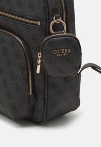 Zaino nero con texture, dotato di accessori in metallo color oro, numerose tasche con cerniera e una mini pochette staccabile con dettaglio logo.