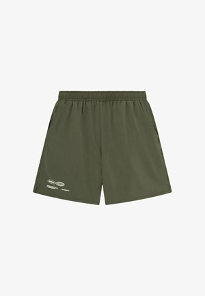 Oliven grønne elastiske shorts med sidelommer og lille hvidt grafisk tryk på den nederste venstre ben.