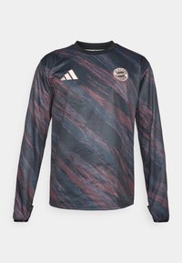 Tumedat käised, tumesinine ja marooniga jerses, millel on tekstureeritud ja laineline mustriline disain. Fookuses must kaelus ja FC Bayern Muncheni logo rinnal.