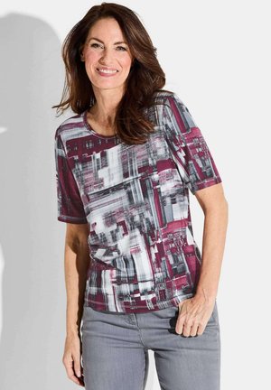 T-shirt à manches courtes avec un imprimé abstrait maroon, gris et blanc. Tissu lisse avec un col rond et une coupe décontractée.