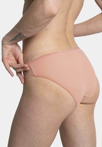Culotte de bikini pour femmes couleur pêche en tissu lisse, avec des accents en dentelle aux hanches et une coupe classique.