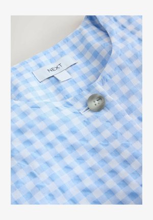 Blau-weiß kariertes Blusentop mit rundem Ausschnitt, einem grauen Knopf und einem Stoffetikett mit der Aufschrift "NEXT". Texturiertes Baumwollmaterial.