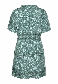 Robe verte à manches courtes avec des pois blancs, taille élastique, volants superposés et un ourlet volanté.