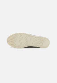 Světlé šedé slip-on boty s textilním svrškem a gumovou podrážkou s cikcakovým vzorem a logem "TOMS".