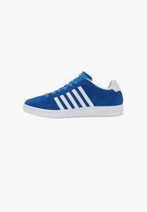 Baskets basses bleues avec semelle blanche et quatre rayures blanches sur le côté, avec des lacets bleus et une languette blanche au talon.