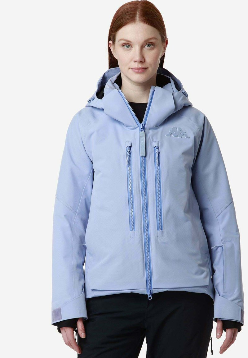 Giacca impermeabile azzurro chiaro con cappuccio, due tasche frontali con zip e polsini elasticizzati. Caratterizzata da una texture liscia e un design sportivo.