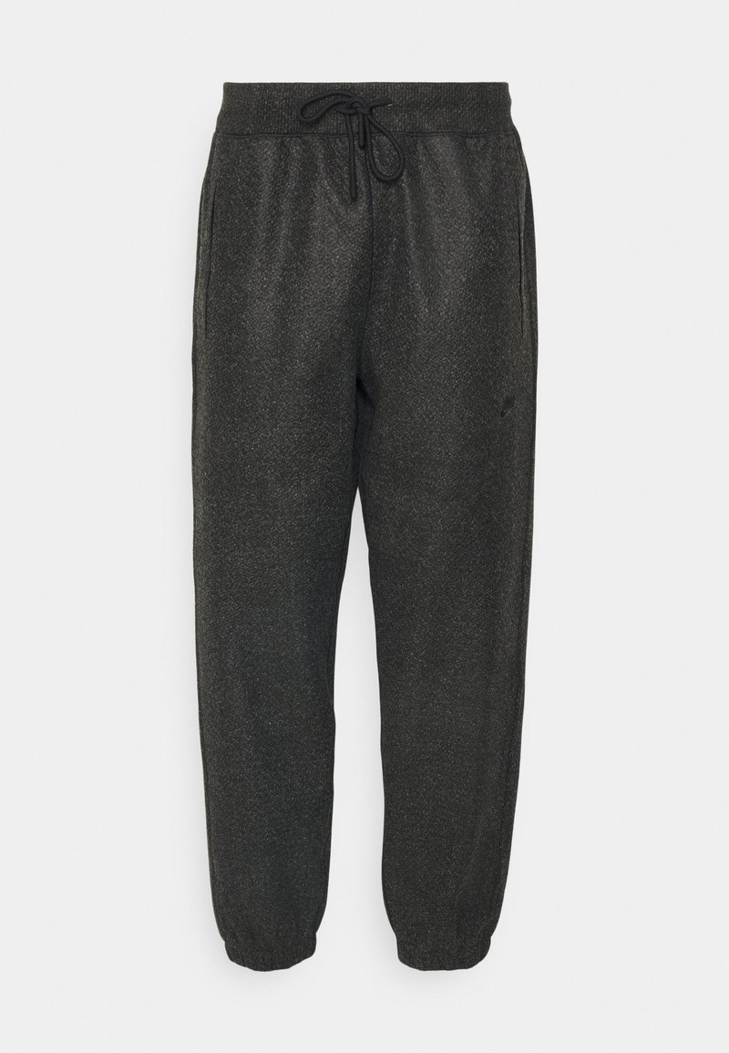 Pantalons de jogging noirs en tissu texturé, avec une taille élastique à cordon de serrage, des poches latérales et des poignets fuselés.