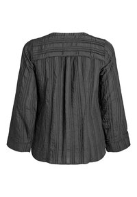 Crna bluzica s teksturom koja ima plisirani stražnji dizajn, duge rukave i horizontalne šavove duž jareta.