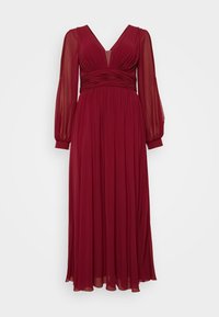Burgundy long dress with long sheer sleeves, V-neck, and pleated waist detail. Soft, flowing fabric creates a smooth silhouette.