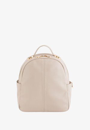 Hellbeige Leder-Rucksack mit runder Form, Obergriff, goldenen Hardware-Akzenten und seitlicher Reißverschlusstasche. Glatte Textur.