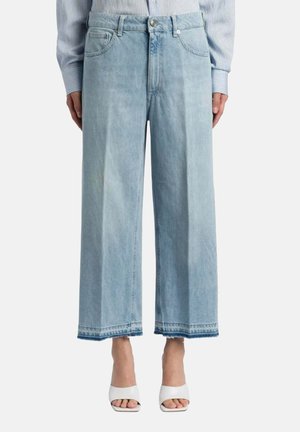 Lichtblauwe wide-leg cropped jeans gedragen met een gestreept shirt en witte open teen hakken, getoond van taille tot voeten.