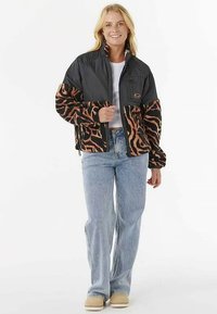 Black and orange zip-up jacket with a textured animal print, featuring a black upper section and a logo patch on the chest.