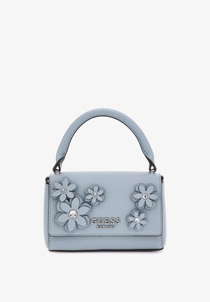 Lichtblauwe handtas met bovenhandvat, versierd met verhoogde bloemenapplicaties en zilveren studs, met het logo "GUESS EST 1981" aan de voorkant.
